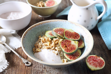 Oatmeal, yogurt, ripe figs, walnutsin bowl and milk