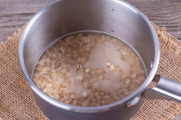 Cooking healthy porridge in metal pot closeup