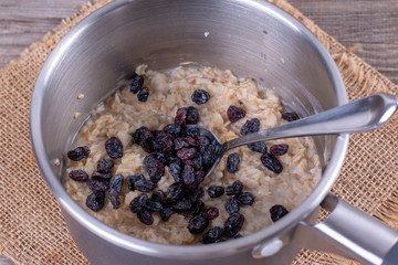Cooking healthy porridge in metal pot closeup