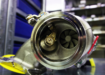 Modern turbocharger on a steel background. Turbocharger element allows you to significantly...