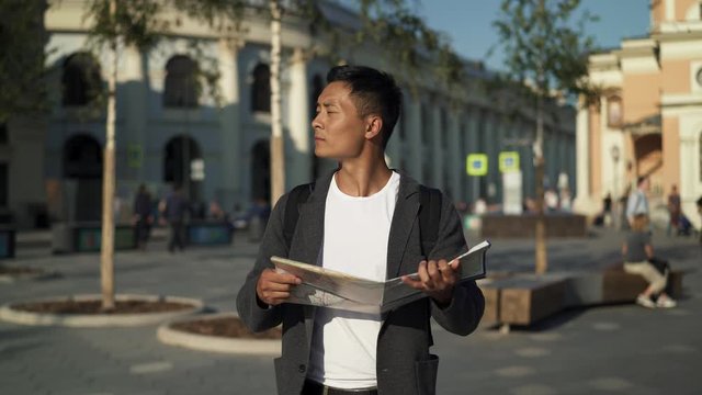 Real time portrait shot of a young tourist looking for attractions with a map in his hands. Moscow is the capital of Russia.