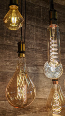Burning light bulbs with original beautiful spirals on a warm brown background. Disain, beauty and comfort indoors.