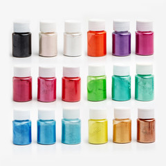 Multi-colored dyes for slimes in transparent jars on a white background. Set of 18 colors. Sparkles for slime. Products for children creativity. Holiday concept.