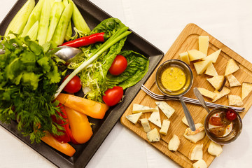 Delicious cheese platter and variety of vegetables on the table