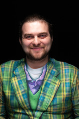 Fototapeta premium portrait of cheerful handsome smiling bearded stylish man in green plaid blazer looking at camera isolated on black
