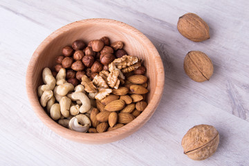 wood serving spoon with Assortment nuts on wooden table. Close-up.