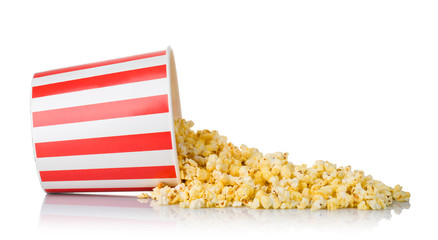 Scattered popcorn from paper striped bucket isolated on white background