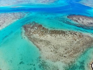 Fototapeta na wymiar Aerial view of shades of blue and coral reefs over the Moorea lagoon in French Polynesia, South Pacific