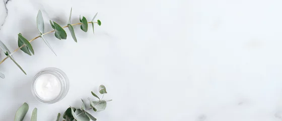 Keuken foto achterwand Natuurlijke organische zalfpot met eucalyptusbladeren op marmeren achtergrond. Plat lag, bovenaanzicht, kopieer ruimte. Natuurlijk biologisch product, schoonheids- en spa-concept © photoguns