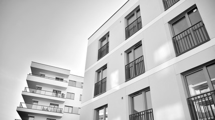 Sun rays light effects on urban buildings. Fragment of modern residential apartment with flat buildings exterior. Detail of new luxury house and home complex. Black and white.