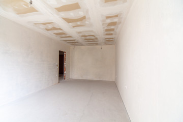 New empty room under construction. Plaster walls. New home. Concrete walls. Interior renovation.