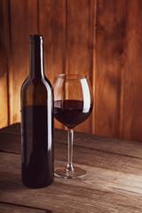 bottle of wine and a glass on old wooden table