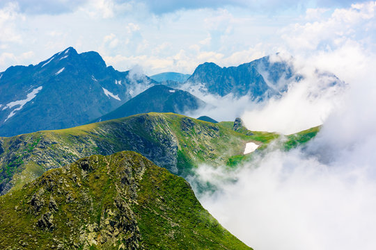 peaks of mountain ridge above the clouds. gorgeous scenery of romanian mountains. fagaras massif in summertime
