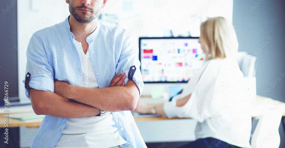 Poster portrait of young designer in front of laptop and computer while working. assistant using her mobile