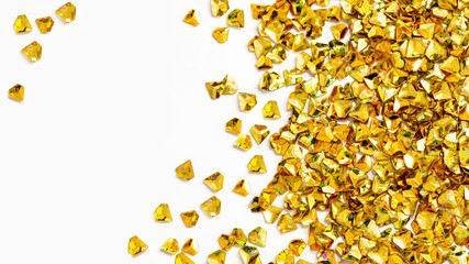 Gold crystals on a white background. The concept of celebration and wealth. Flat lay, copy space. Products for children's creativity.