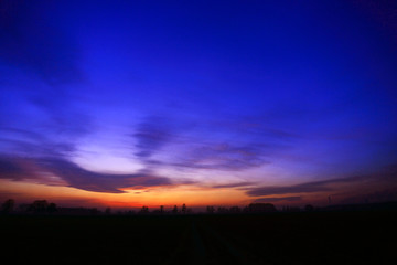 Fototapeta na wymiar Złoty, pastelowy zachód słońca nad polami, obszry wiejskie.