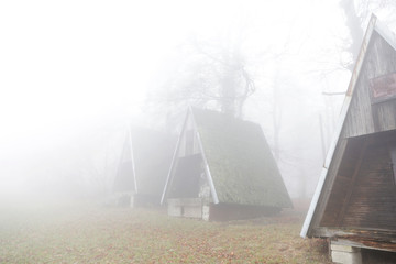 Abandoned cottages in foggy forest. Scary place in autumn forest. Misty moments. Path in the forest. Halloween, lost place. 