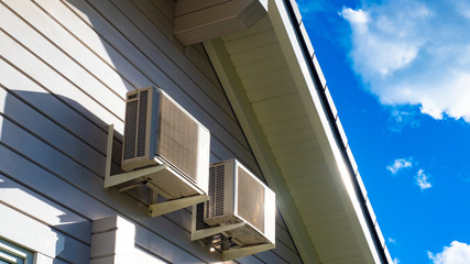 Two air conditioners on the wall of the cottage. Air conditioning on the facade of the building. Air conditioning on the wall of the house. Climate control. Installation of climatic equipment