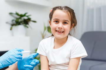 Woman female doctor makes little cute girl toy injection