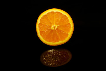 Orange slice isolated on black with reflection