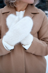 Fototapeta na wymiar Hands in Knitted Mittens. Winter lifestyle. Wearing Stylish Warm Clothes. Woman in warm clothes