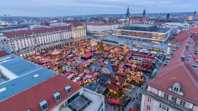 Aerial view of Striezelmarkt, a Christmas market in Dresden and one of the oldest Christmas markets in the World. City skyline. Day to night time lapse video.