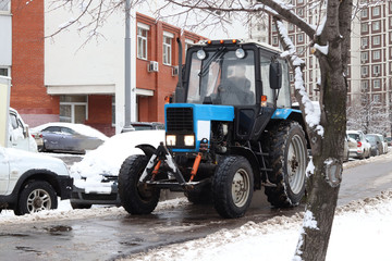 Obraz na płótnie Canvas Snow removal on the streets of a big city. Great equipment, special snowplow.