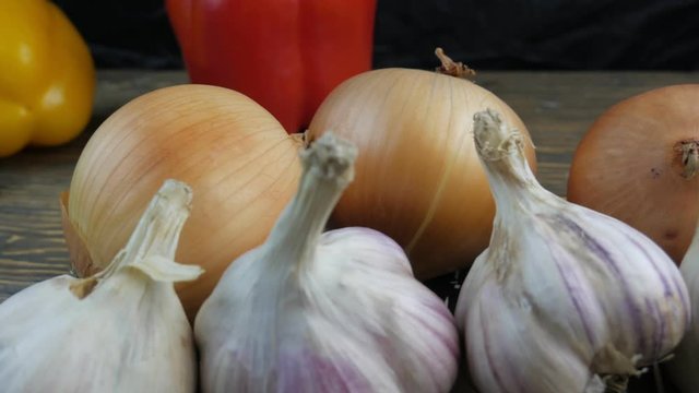 Fresh garlic and onions on a wooden background