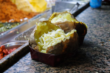 Die Vorbereitung von einem Kumpir mit K&auml;se und Butter 