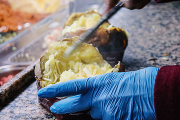 Die Vorbereitung von einem Kumpir mit K&auml;se und Butter 
