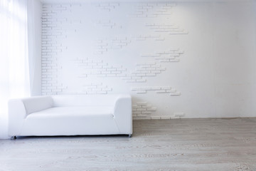 Empty waiting room with a modern gray sofa in front of the door and a clock on the wall