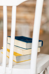 Old colored books on a white chair