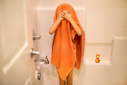 child wearing orange towel after shower