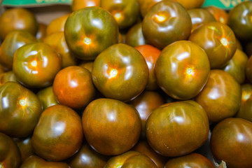 Fresh green Kumato tomatoes in a box. Vegetables, fruits, useful products.