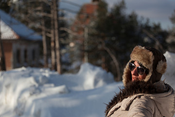 beautiful girl with sunglasses and cap, photographed in the winter on the mountain