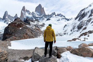 A hiker with a yellow jacket on the base of Fitz Roy Mountain in Patagonia, Argentina