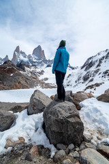 Fototapeta premium A hiker woman with a blue jacket on the base of Fitz Roy Mountain in Patagonia, Argentina