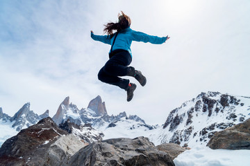 A hiker woman jumping on the base of Fitz Roy Mountain in Patagonia, Argentina
