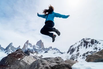 Crédence de cuisine en verre imprimé Fitz Roy A hiker woman jumping on the base of Fitz Roy Mountain in Patagonia, Argentina