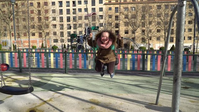 Little girl with down syndrome having fun on the swing