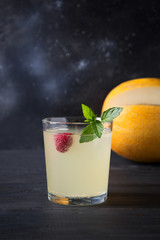 Melon juice in wine glass on dark wooden table