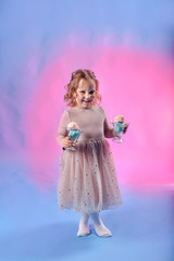 Cute girl with bright bubble gum ice cream of pink and blue color. Against the background of a neon color. Blue and pink light. The concept of summer, disco