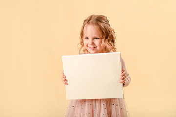 Cute curly girl of four years old. laughs emotionally. In a smart pink dress.Girl holding white...