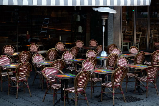 Tische und St&uuml;hle ohne G&auml;ste vor einem Caf&eacute; mit gestreifter Markise im Winter bei Sonnenschein an der Konstablerwache in der City von Frankfurt am Main in Hessen