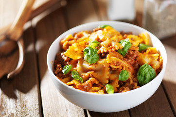 farfalle pasta with hamburger meat and basil leaves in spaghetti sauce