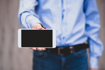 Business man holds and shows mobile phone. Bearded man in suit showing smart phone with blank screen. Business, communication, internet, technology concept