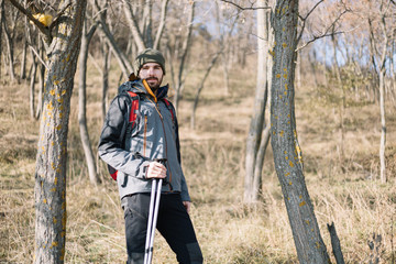 Active man with hiking equipment standing in the nature