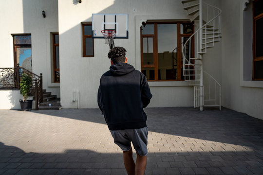 Young man playing basketball outdoors in the backyard | shooting a ball at the rim | Natural image