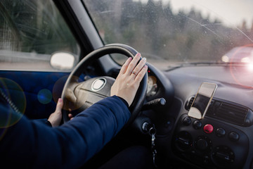 Naklejka premium woman drives a car, holds the steering wheel on a trip.