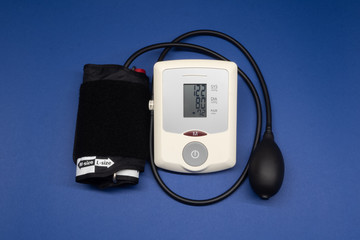 Blood pressure tonometer on a blue background with the measurement result.